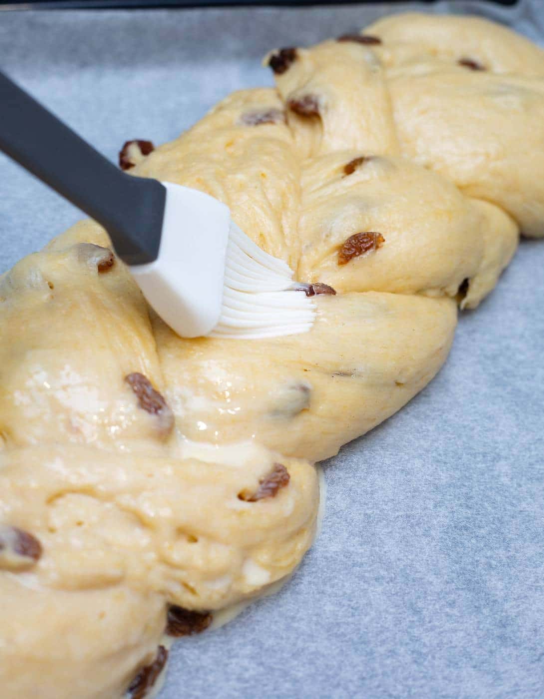 Rozijnen vlechtbrood bestrijken met ei