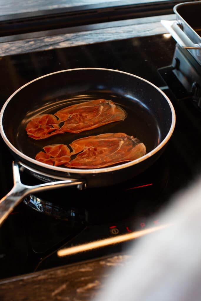 Serranoham word uitgebakken in een koekenpan