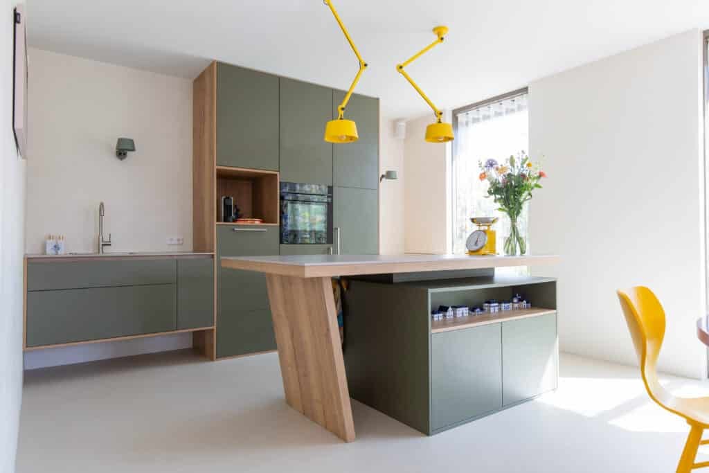 Groene eilandkeuken met kooktafel in een nieuwbouwwoning in Nijkerk